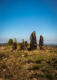 Standing sacred stone monoliths with bright blue sky and grass from a different perspective