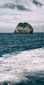 Scenic view of rocks in sea against sky