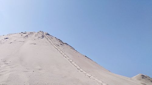 Scenic view of desert against clear blue sky