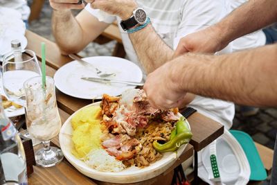 Midsection of friends having food at restaurant