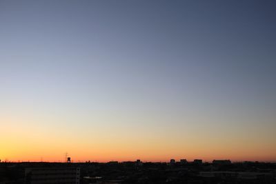 Silhouette buildings against clear sky during sunset