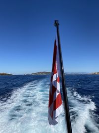 Sailboat on sea against clear blue sky