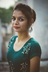 Portrait of beautiful woman standing against blurred background