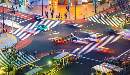 High angle view of people and vehicles on street in city