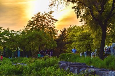 Rear view of people walking on landscape against sky