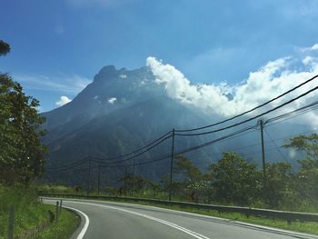 Road by mountain against sky