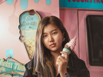 Portrait of young woman holding camera