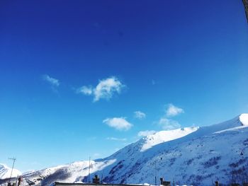 Scenic view of snow mountains against blue sky