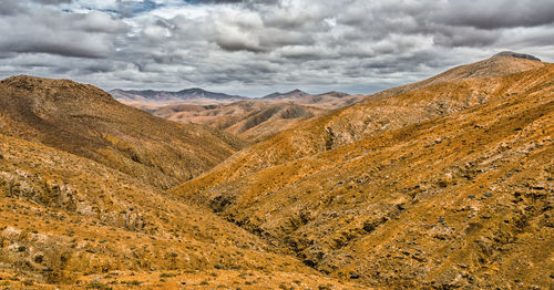 Scenic view of mountains against cloudy sky