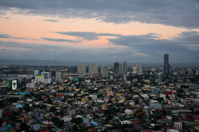 Aerial view of buildings in city against sky during sunset