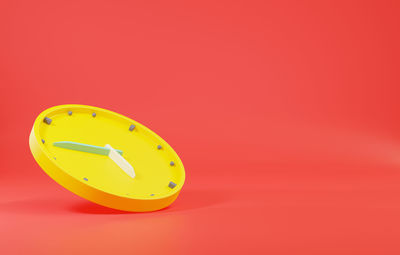 High angle view of yellow clock against orange background