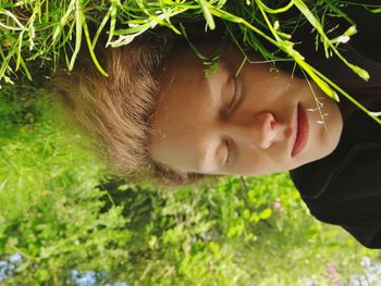 Close-up of young man sleeping on grassy field