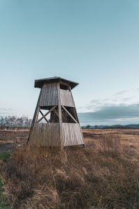 Traditional windmill on field against clear sky