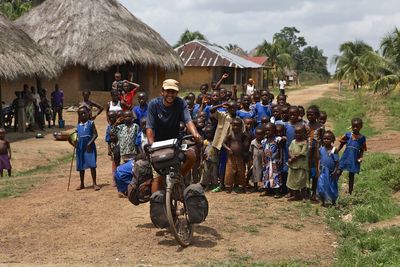 People on field saluting mailman on bicycle