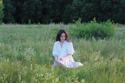 Full length of a smiling woman standing on field