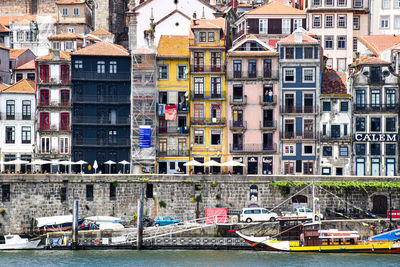 Boats moored in canal by buildings in city