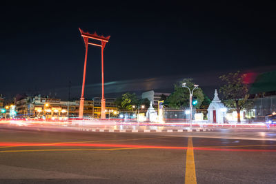 Light trails on road against sky at night