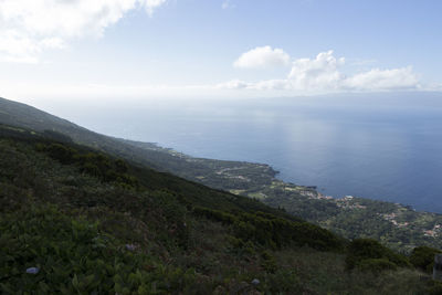 Scenic view of sea and mountains against sky