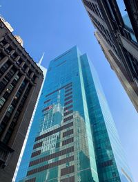 Low angle view of modern buildings against clear blue sky