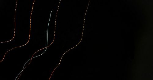 Close-up of illuminated lights over black background