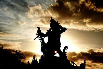 Low angle view of silhouette statue against sky during sunset