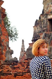 Low angle view of woman at temple against building