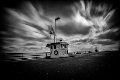 Street light on road by sea against sky