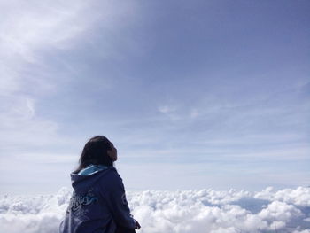 Low angle view of woman standing against sky