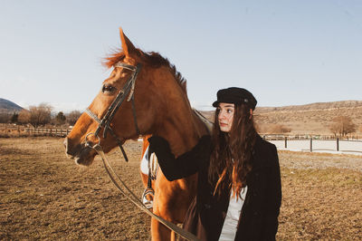 Young woman with horse on the field