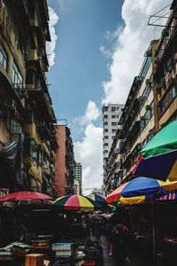 People at street market in city against sky