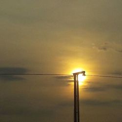 Low angle view of street light against sky at sunset