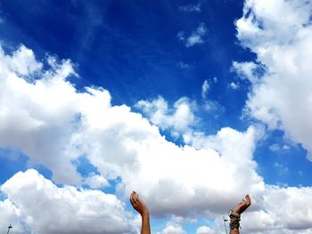 Cropped image of hands against sky