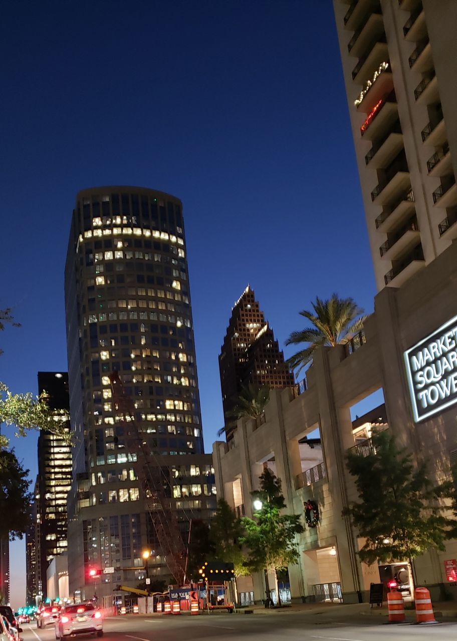 LOW ANGLE VIEW OF ILLUMINATED BUILDINGS AT NIGHT