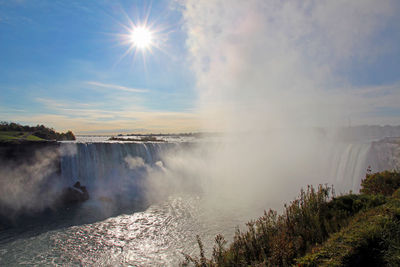 Scenic view of waterfall against sky