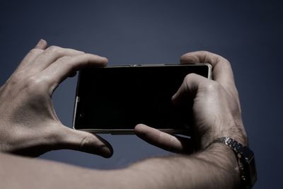 Cropped hands of man holding mobile phone