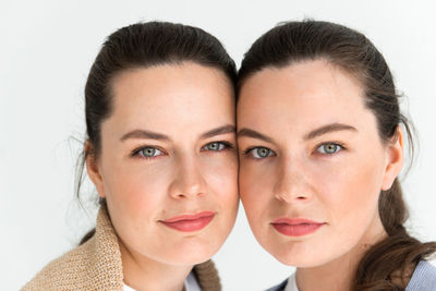 Two beautiful women twin sisters close-up face portrait