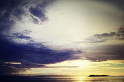 Scenic view of sea against cloudy sky during sunset