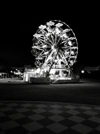 Illuminated ferris wheel at night