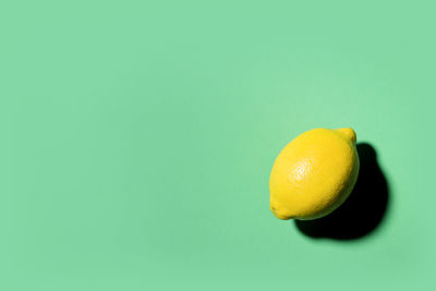 Close-up of lemon against green background