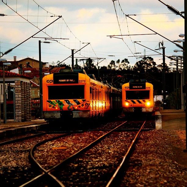 railroad track, rail transportation, transportation, public transportation, power line, building exterior, electricity pylon, mode of transport, railroad station, sky, train - vehicle, railroad station platform, electricity, power supply, cable, built structure, architecture, railway track, outdoors, travel