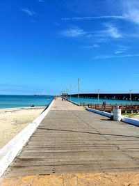 Pier over sea against blue sky