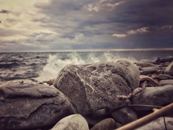 Close-up of rocks on beach against sky