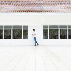 Side view of woman standing against building