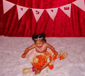 High angle view of little birthday girl crying with messy cake