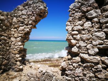 Rock formation on beach against sky