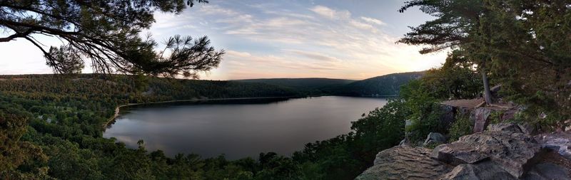 Scenic view of river by mountains against sky