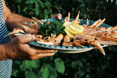 A man is serving crayfish at a garden party