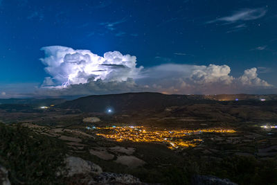 Aerial view of illuminated landscape against sky at night