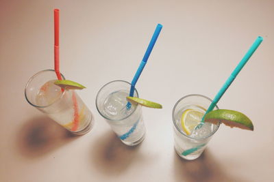 High angle view of highball cocktails with multi colored straws on table