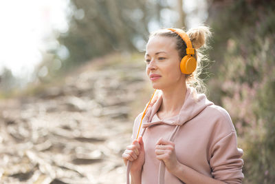 Woman looking away while standing outdoors